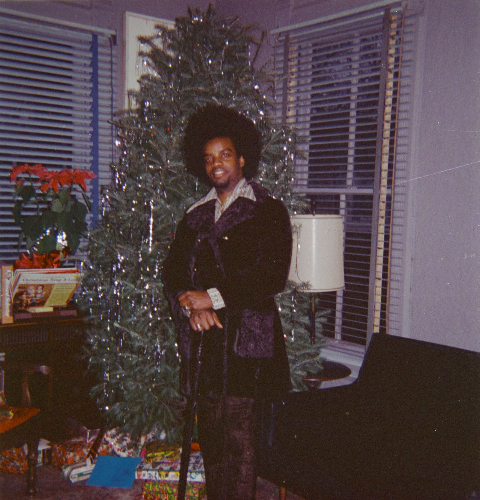 Joseph Burrell posing by a Christmas tree, 1972 Digital Collections
